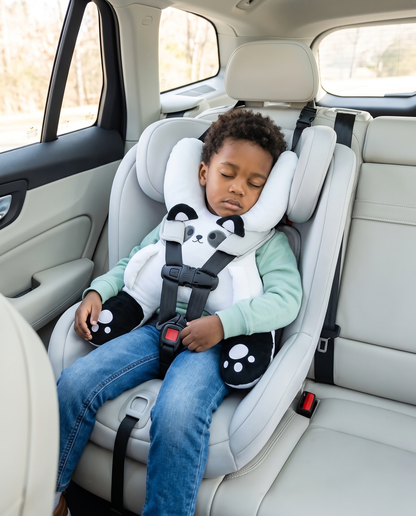 Boy asleep in a car seat wearing the Kudlee white panda nap pillow