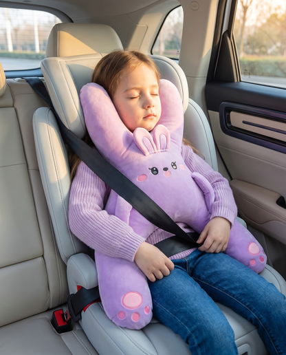 Girl asleep in a booster seat wearing the Kudlee purple bunny nap pillow