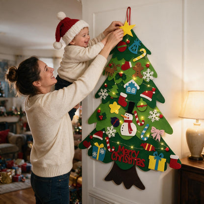 Mum lifting her toddler to put the star on top of his felt Christmas tree